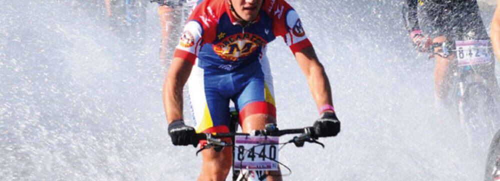 Cyclists crossing water during a race in Uruguay, showcasing outdoor sports and adventure.