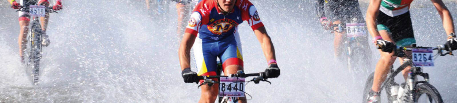 Cyclists crossing water during a race in Uruguay, showcasing outdoor sports and adventure.