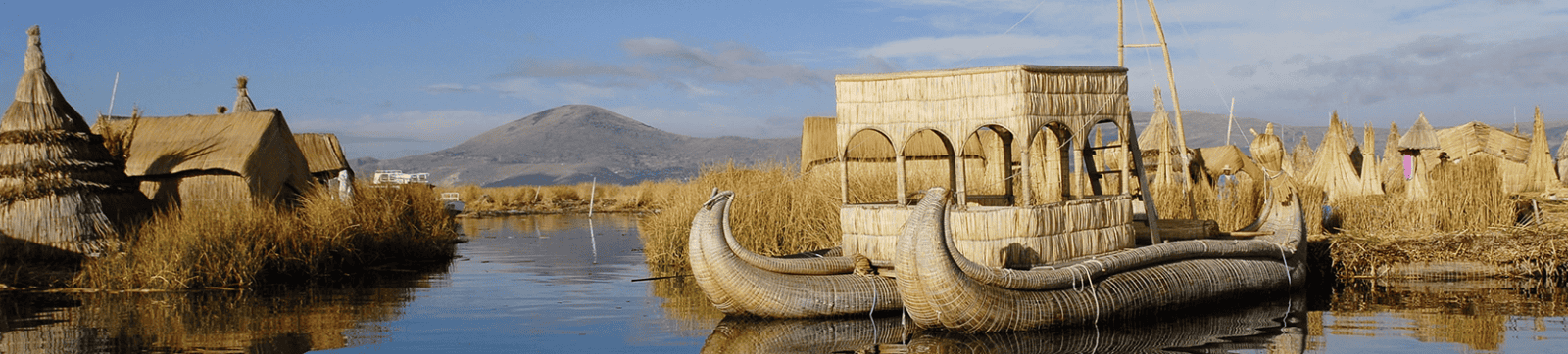 Antiguo barco de pesca en un río con aldeas tradicionales y montañas al fondo.