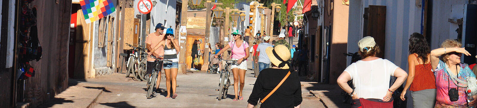 Vibrant street festival scene with people enjoying colorful decorations and lively atmosphere.