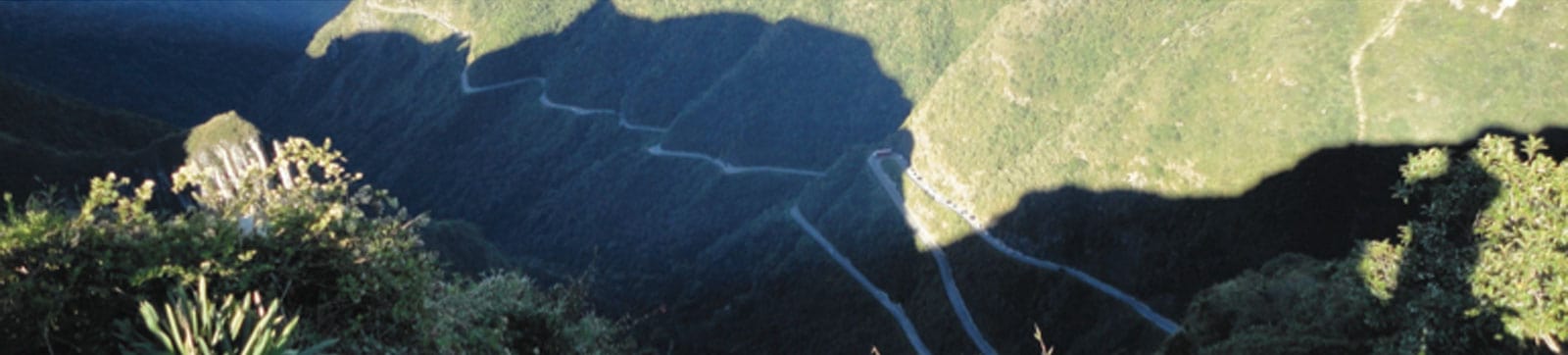 Mountain landscape with lush greenery and winding paths.