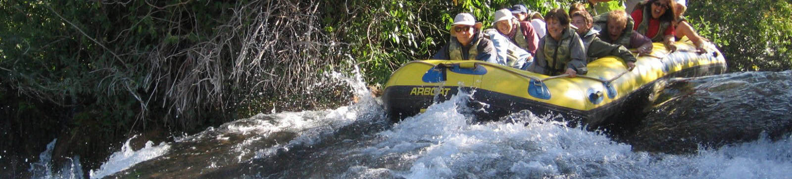 Aventuras en rafting en río con grupo de personas disfrutando la naturaleza.