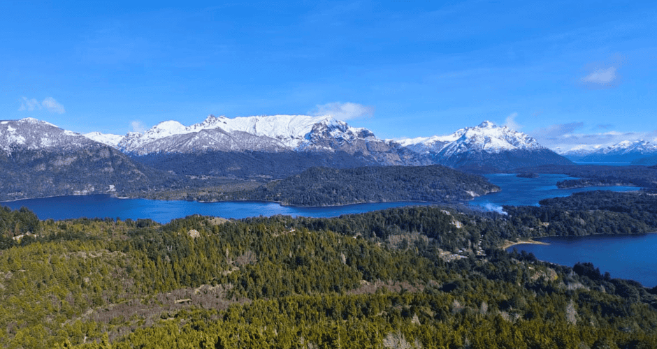 Cascada de montañas y lagos en un paisaje natural con nieve en las cumbres.