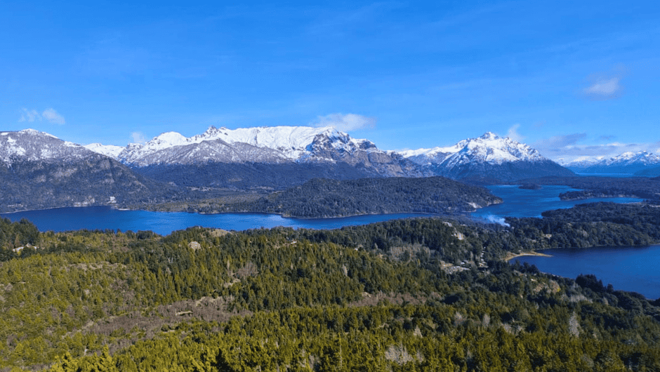 Cascada de montañas y lagos en un paisaje natural con nieve en las cumbres.