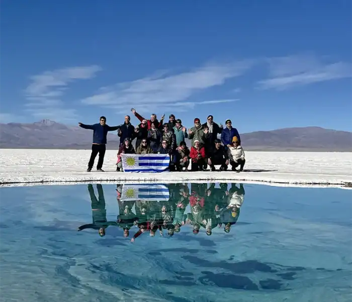 grupo de viajeros de el kaminante posando con la bandera de uruguay