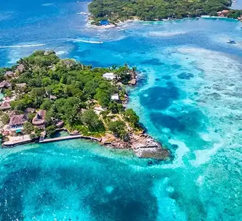 A lush tropical island surrounded by clear blue waters and coral reefs.
