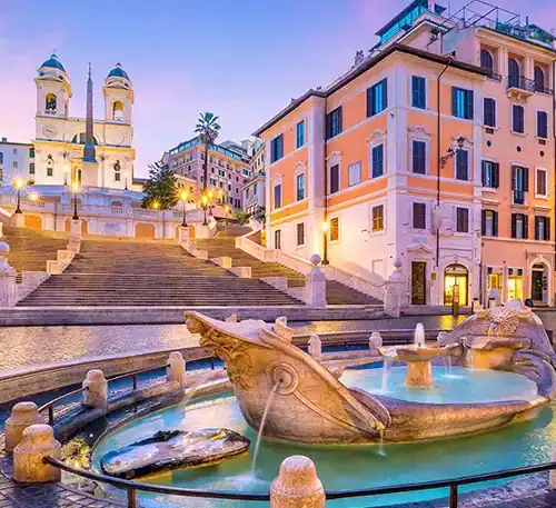 Historic square with fountain and colorful buildings in a European city at dusk.