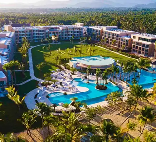 Luxury resort with pools and lush gardens in a tropical setting.