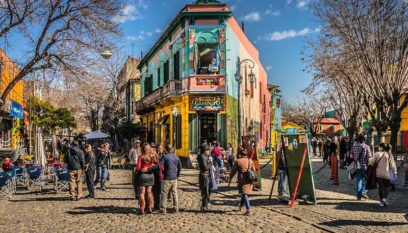 Paseo en una calle peatonal con edificios coloridos y gente disfrutando del día en Montevideo, Urugu.