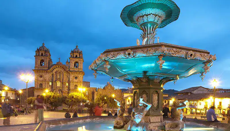 Fuente histórica en la plaza principal de El Camino, iluminada al atardecer con un hermoso cielo azu.