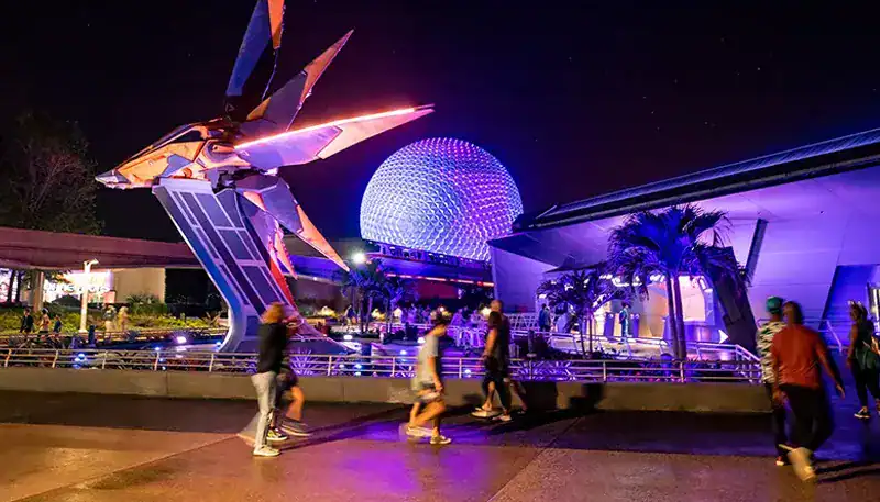 Un robot gigante iluminado en un parque temático nocturno en El Kaminante.