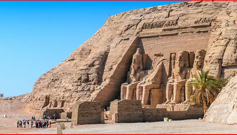 Ancient Egyptian statues at Abu Simbel, carved into a sandstone cliff.
