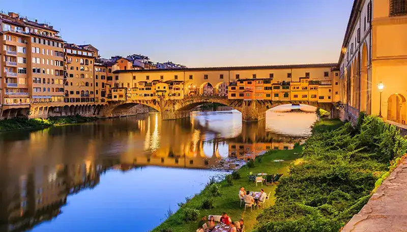 Ponte Vecchio bridge over Arno River in Florence at sunset, Italy.