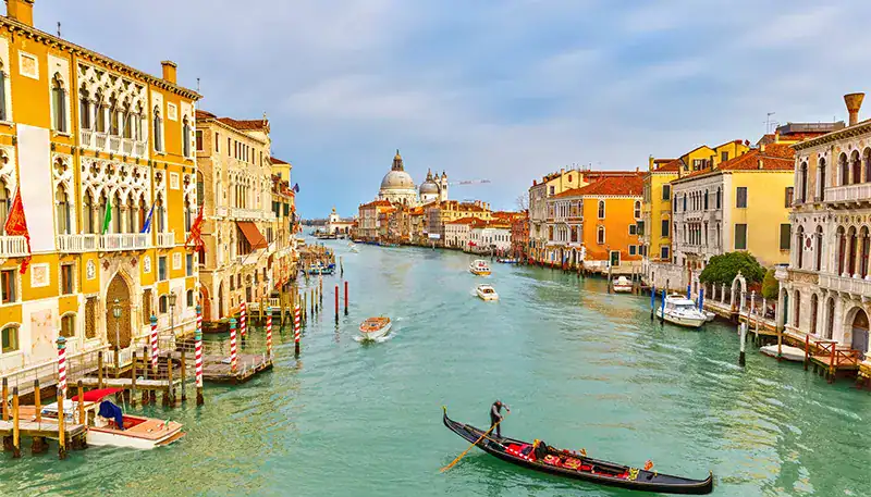 Puente de Rialto en Venecia, con góndolas navegando por el canal principal.