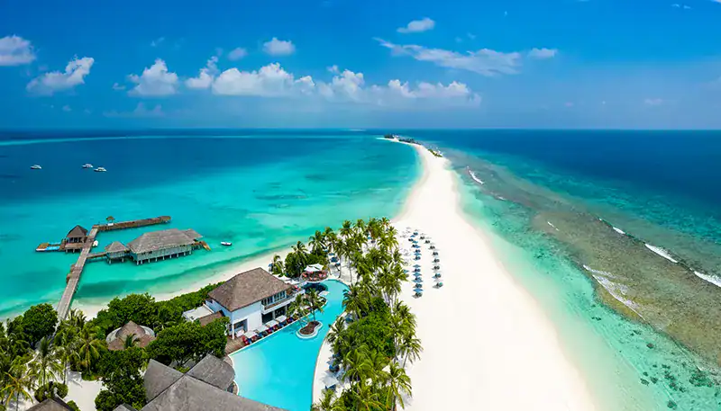 Relaxing tropical beach with turquoise waters and overwater bungalows at El Kaminante.