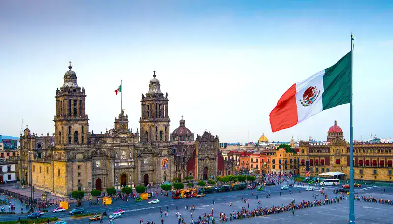Catedral Metropolitana de la Ciudad de México con bandera mexicana en primer plano.