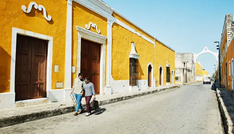 Calle colorida en un pueblo colonial de Uruguay con edificios vibrantes y calles empedradas.