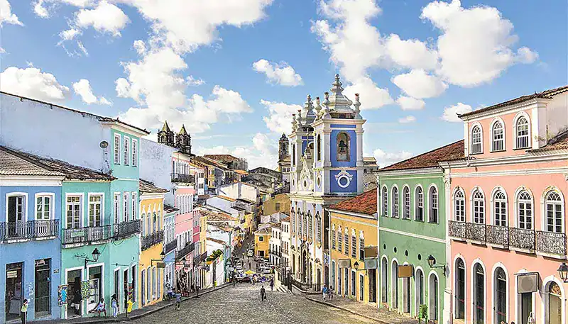 Calle colorida en un pueblo colonial con edificios históricos y cielo despejado.