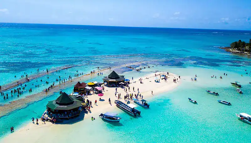 Relaxing beach scene with turquoise waters and boats at a tropical island.