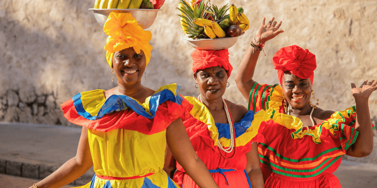 Vendedoras con trajes tradicionales coloridos en una celebración cultural en Uruguay.