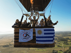 Veleros en vuelo con bandera de Uruguay y logo de El Kaminante en el globo aerostático.