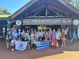 Grupo de turistas en el ingreso del Parque Nacional Iguazú, con banderas de Uruguay y Argentina.