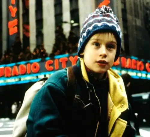 Chico con gorro en la ciudad, en un entorno urbano con luces y edificios.