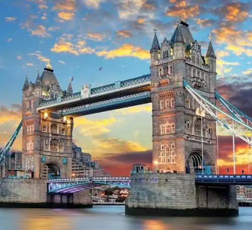 Puente de Londres al atardecer con cielo colorido y reflejo en el río.